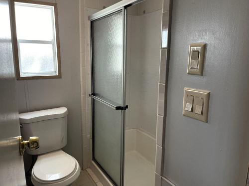 a bathroom with a toilet and a glass shower door at Amazing 1 bedroom Near Disney in Seven Points