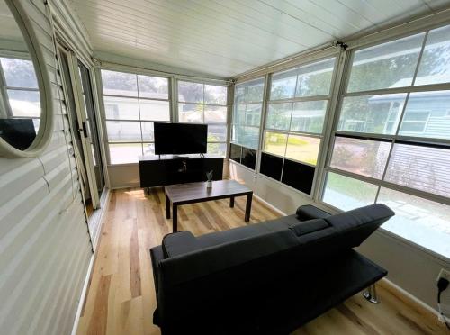 a living room with a couch and a table and windows at Amazing 1 bedroom Near Disney in Seven Points
