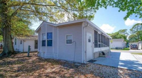 a white house with a tree in front of it at Amazing 1 bedroom Near Disney in Seven Points