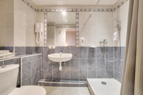 a bathroom with a sink and a toilet and a mirror at Hotel Lepante in Nice