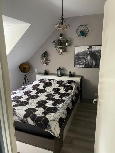 une chambre avec un lit à carreaux noirs et blancs dans l'établissement Appartement, à Quimper