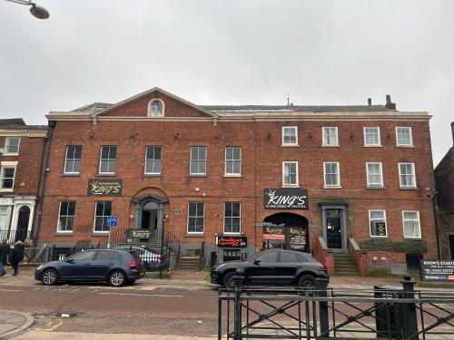 a brick building with two cars parked in front of it at King Street Hotel in Blackburn