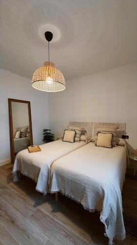 a bedroom with two beds and a chandelier at La Casa del Escudo in Trujillo