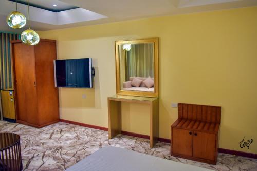 a living room with a mirror and a chair at Red Sea Hotel in Būr Tawfīq