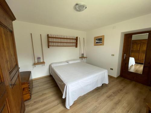 a bedroom with a white bed and a wooden floor at Casa Marco - Ca' di chi de Zirie - in Pelos