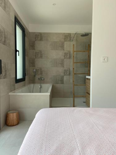 une chambre avec un lit, une baignoire et un lavabo dans l'établissement Villa spacieuse piscine 350 m de la plage, au Grau-dʼAgde
