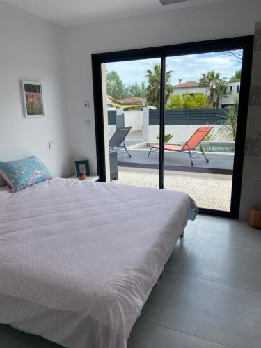 - une chambre avec un lit et une vue sur une terrasse dans l'établissement Villa spacieuse piscine 350 m de la plage, au Grau-dʼAgde