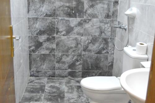 a bathroom with a toilet and a sink at Beautiful Salalah Beach Apartments - 3 By Beautiful Salalah Tours in Salalah