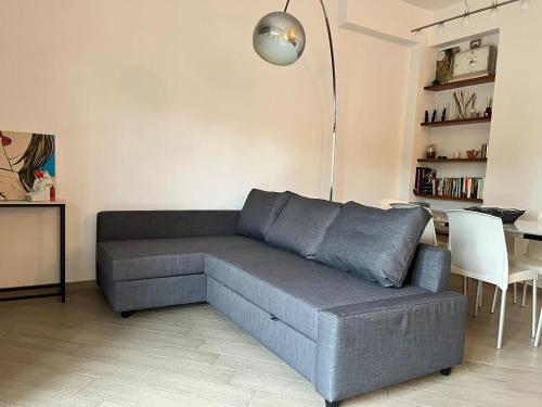 a living room with a gray couch and a lamp at La casa di Andrea in Messina