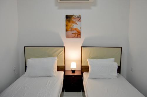 two beds sitting next to each other in a bedroom at Beautiful Salalah Beach Apartments - 3 By Beautiful Salalah Tours in Salalah