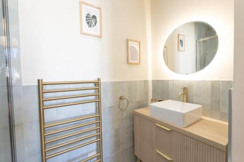 une salle de bain avec un lavabo et un miroir dans l'établissement Le Soleil, à Antibes