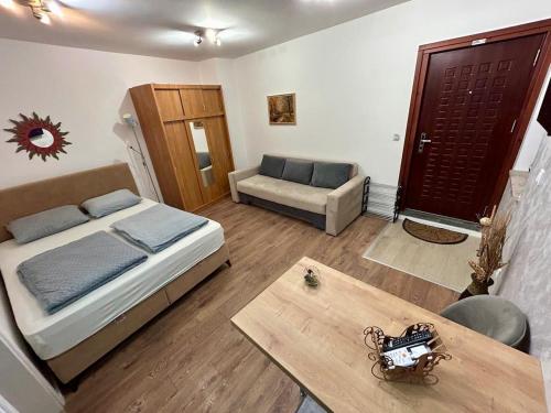 a bedroom with a bed and a couch and a table at Studio Baščaršija - Sarajevo's prime location in Sarajevo
