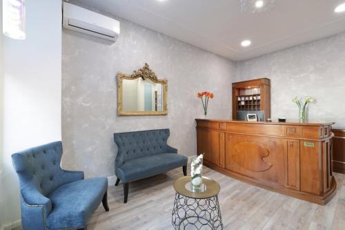 a living room with two blue chairs and a mirror at Hotel Lepante in Nice