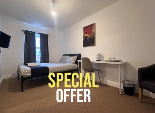 a room with a bed and a desk and a chair at King Street Hotel in Blackburn