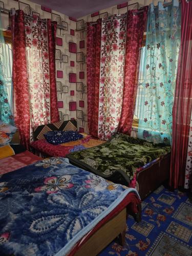 a room with two beds with curtains and a cat laying on it at Queen Palace guest house in Srinagar
