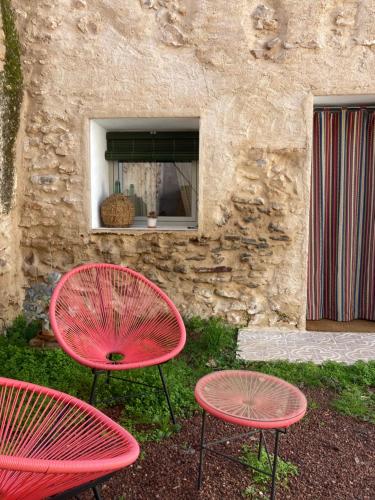 three red tables and chairs in front of a building at La Santa in Almagro
