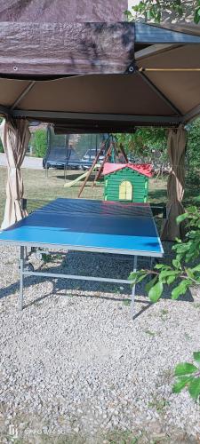 a blue bench under a tent with a play structure at Gîte de la Source in Barret-sur-Meouge