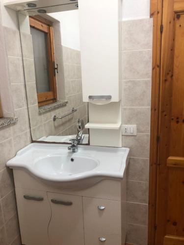 a bathroom with a white sink and a mirror at Appartamento San Teodoro III in San Teodoro
