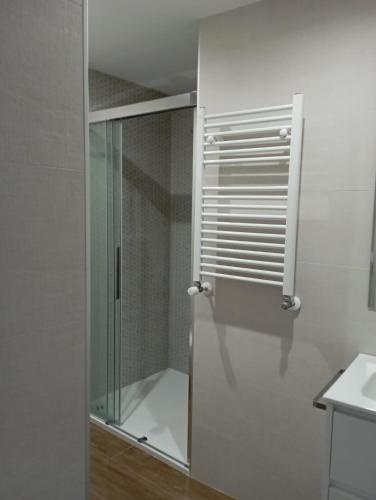 a glass shower door in a bathroom with a sink at La Fuente in Luarca