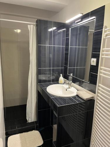 a bathroom with a sink and a mirror at Belvárosi Rezidencia Pápa in Pápa