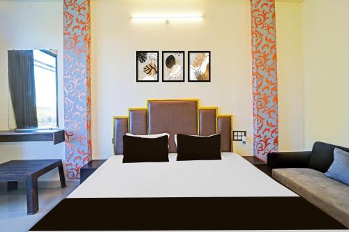 a bedroom with a large bed and a couch at Super Hotel O York Residency in Bhopal