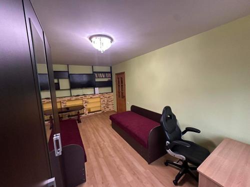 a bedroom with a bed and a desk and a chair at Privatūs apartamentai in Mažeikiai