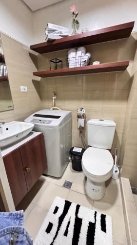 a bathroom with a white toilet and a sink at GreySky Studio in Manila