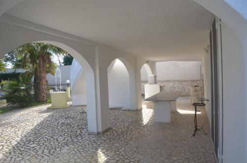 Habitación blanca con mesa y suelo de piedra. en Raucci House, en Torre Squillace