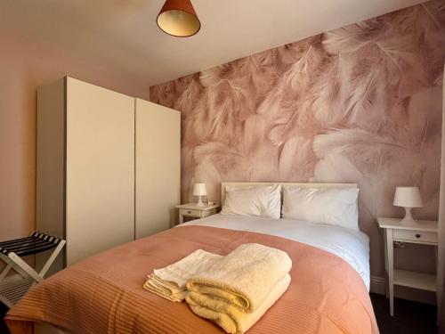a bedroom with a bed with towels on it at Mandeville Guest House in Enfield Lock