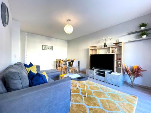 a living room with a blue couch and a television at Dream Saint-Georges à proximité de Disneyland in Bussy-Saint-Georges