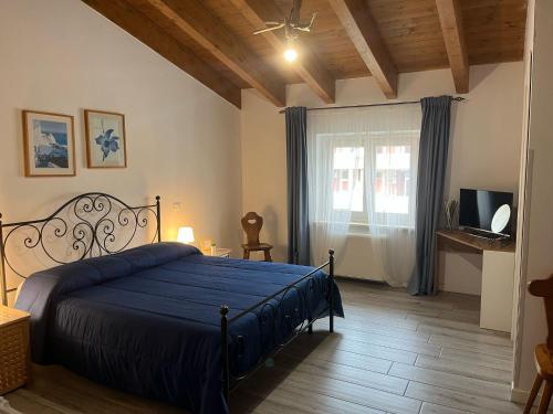 a bedroom with a blue bed and a window at Nottola B&B in Ladispoli
