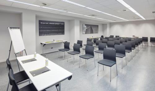 a room with rows of tables and chairs in a classroom at Sercotel Boulevard Vitoria-Gasteiz in Vitoria-Gasteiz