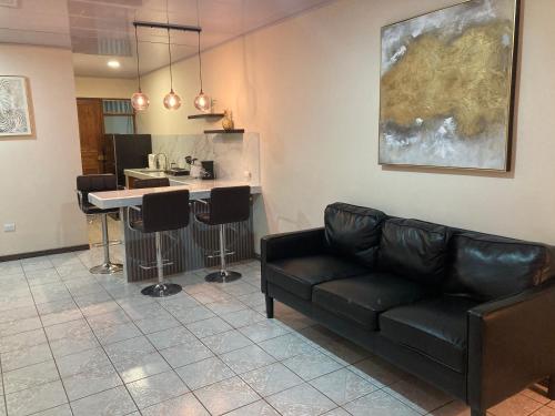 a living room with a couch and a kitchen at Hospedaje Ana Lu 1 Only 10 minutes from airport in Alajuela