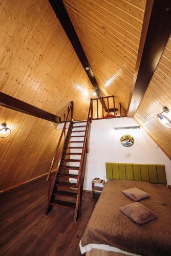a bedroom with a staircase and a bed in a room at Aframe LINIȘTEA PĂDURII NĂMĂEȘTI in Nămăeşti