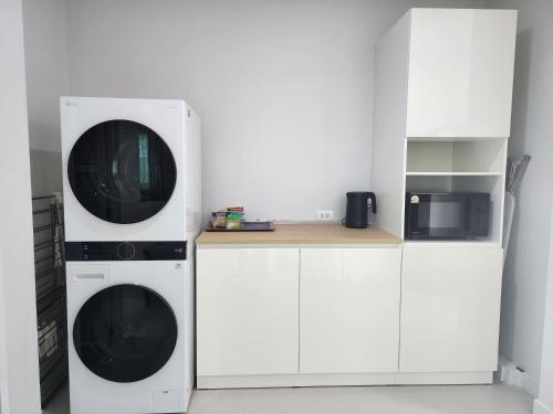a kitchen with two washing machines and a microwave at MB Home in Ban Bang Khu