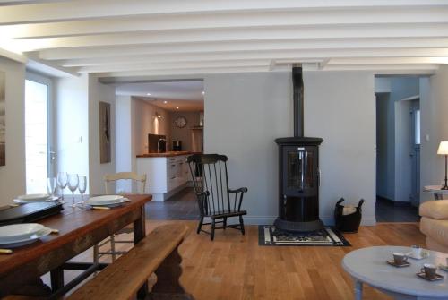 a living room with a dining table and a fireplace at Maison de pêcheur à 1,5km de la mer in Blainville-sur-Mer
