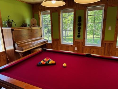 a pool table in a room with a piano at le Studio in Tadoussac