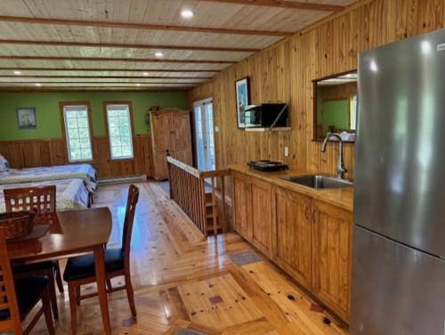 a kitchen with a stainless steel refrigerator and a table at le Studio in Tadoussac