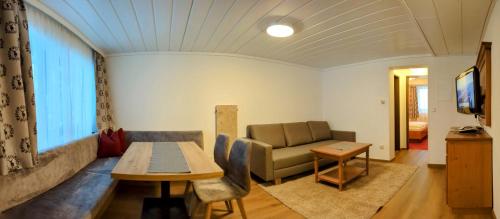 a living room with a couch and a table at Ferienhotel Gasthof zur Post in Untertauern