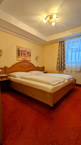 a bedroom with a large wooden bed in a room at Ferienhotel Gasthof zur Post in Untertauern