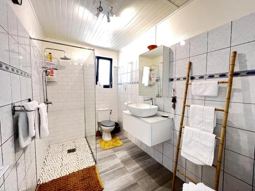 a white bathroom with a sink and a toilet at Villa K'nopée in Sainte-Marie