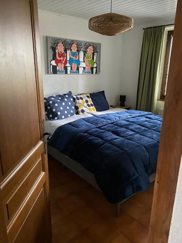 une chambre avec un lit avec une couette bleue dans l'établissement Magnone Vacance - Gîte Le Petit Ruisseau, à Lavercantière