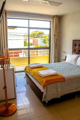 a bedroom with a bed and a large window at DEL VALLE HOUSE II in Ica