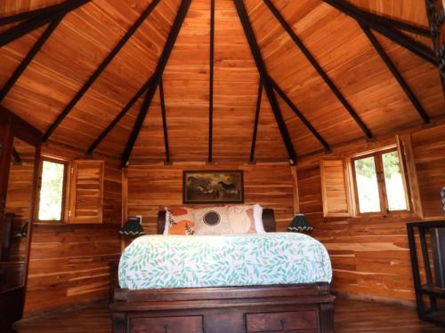 a bedroom with a bed in a wooden room at La Gloria Reserva Forestal in La Calera