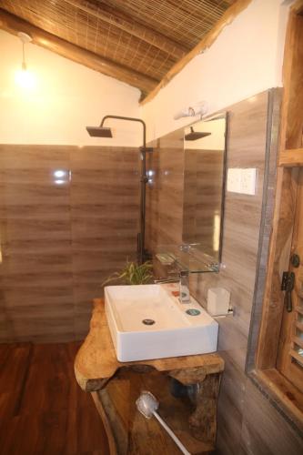 a bathroom with a white sink and a mirror at Jungle Cave in Ella