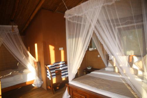 a bedroom with a bed with white mosquito netting at Jungle Cave in Ella