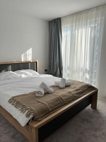 a bedroom with a bed with two towels on it at LaLa HOME in Oradea