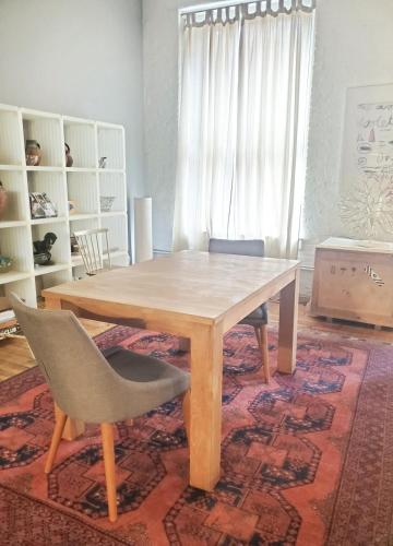 a dining room with a wooden table and a chair at Beach Street Loft in Boston