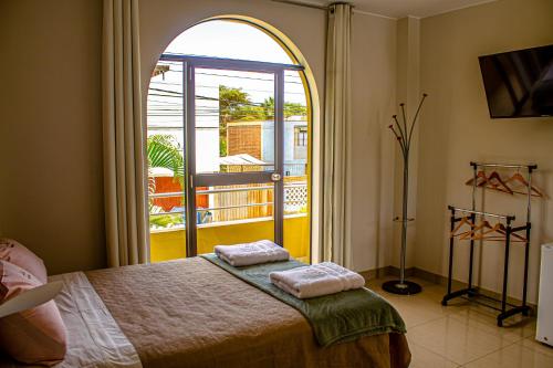 a bedroom with a bed and a large window at DEL VALLE HOUSE II in Ica