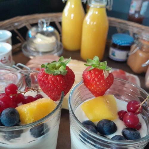 une table avec deux verres de fruits et de lait dans l'établissement glamping met landelijk uitzicht, à Spanga